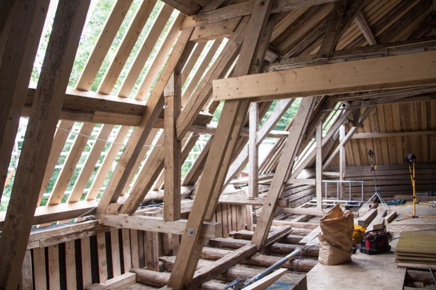 På baksidan av ladugården pågår nu arbetet med att laga taket. Foto: Per Hallén 2016